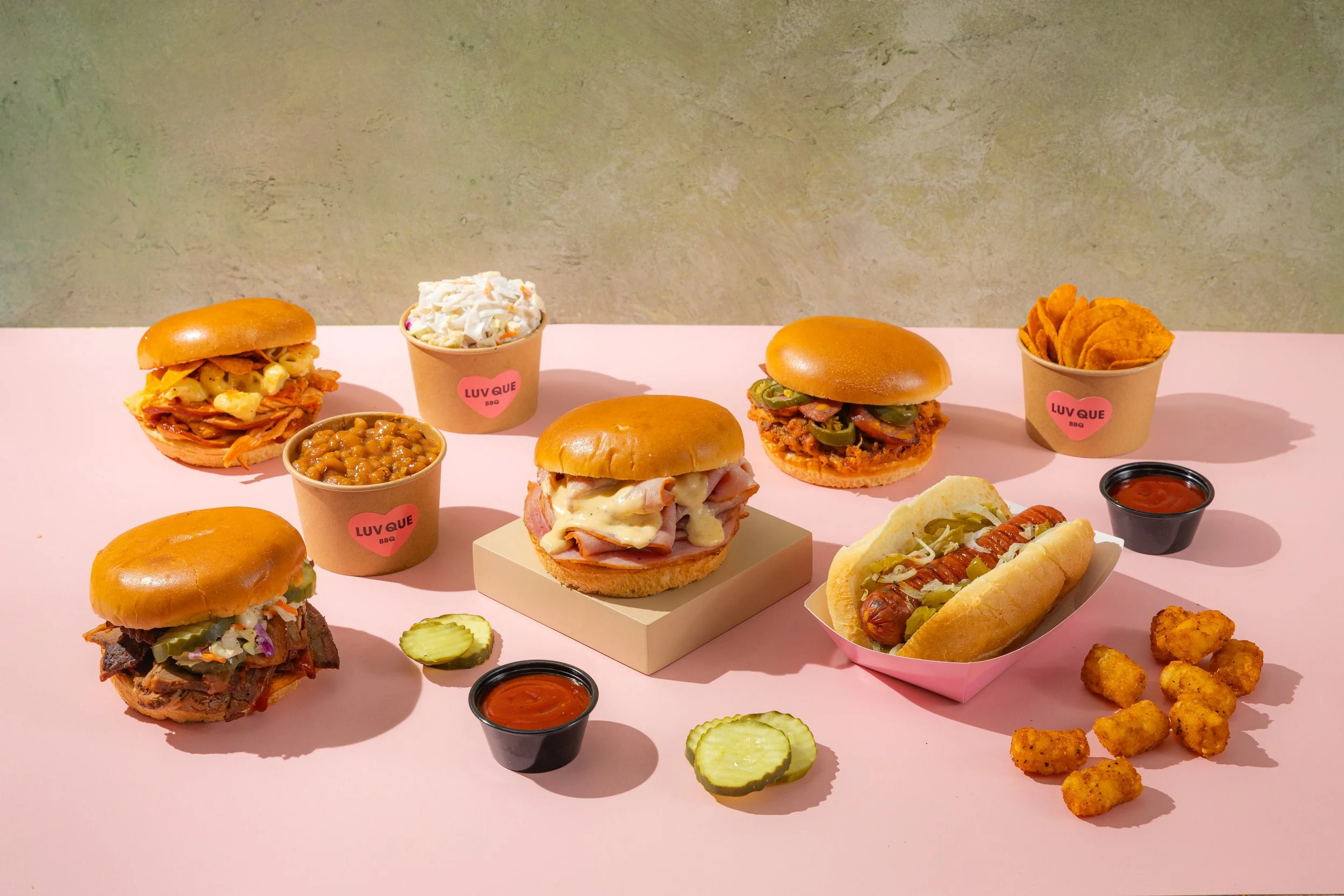 Luv Que BBQ spread: sandwiches, mac & cheese, sausage, sides and sauces